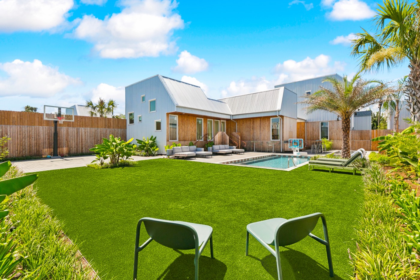Big lawn with cornhole, villa and private pool behind at a New Orleans group property